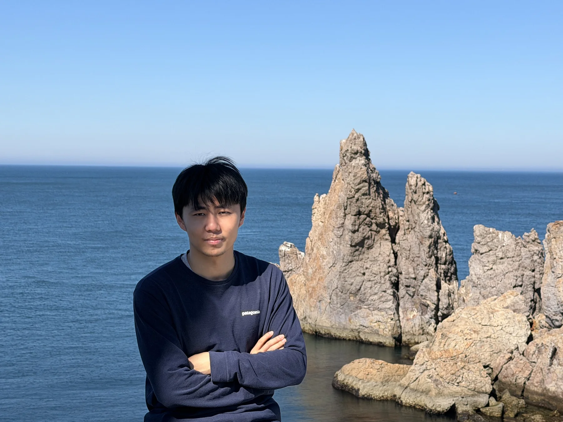 韩涛站在海边礁石前